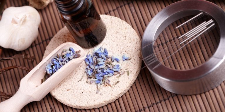 Heilpflanze, Öl-Fläschchen und Nadeln für die Akupunktur